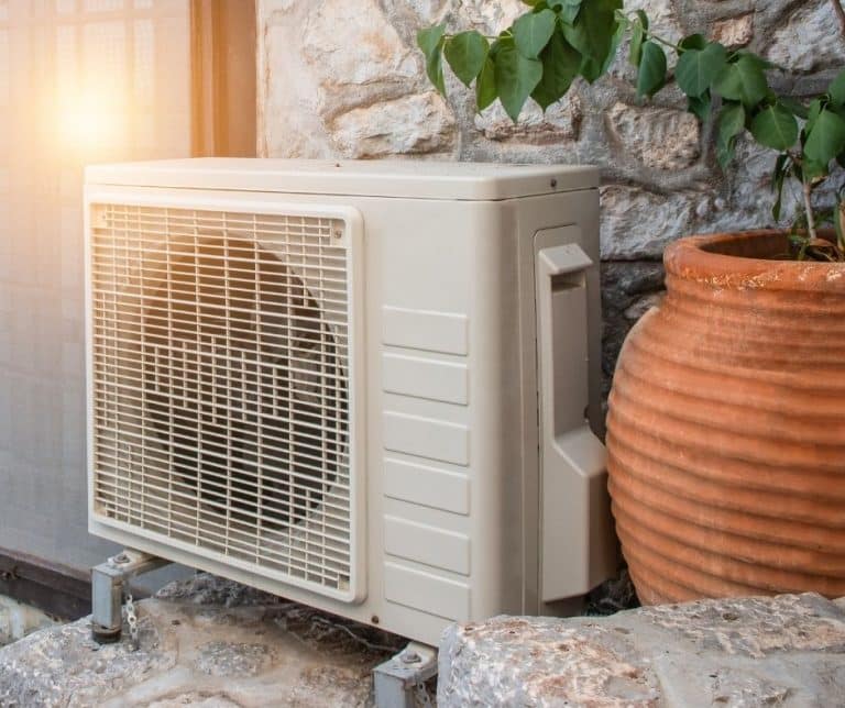 Modern heat pump sitting outside on someone's porch